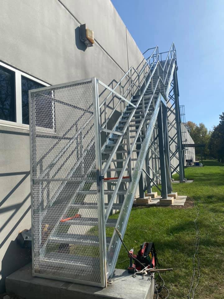 A metal staircase is next to the side of a building.