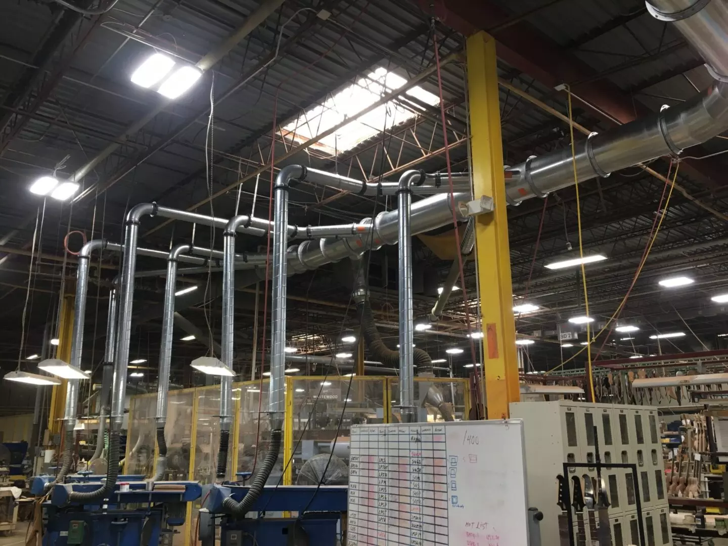 A factory with pipes and wires hanging from the ceiling.