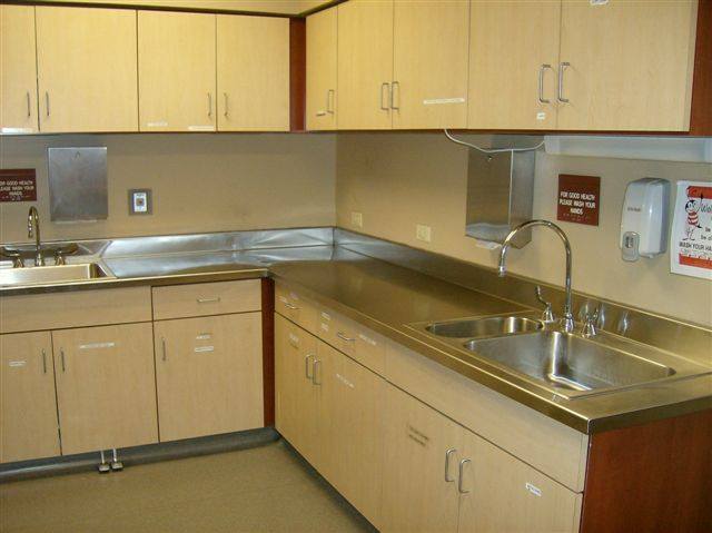 A kitchen with stainless steel counters and cabinets.
