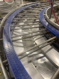 A conveyor belt with blue strips on it.